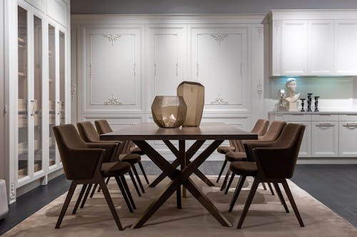 Stylish modern dining room with white cupboards and comfy armchairs