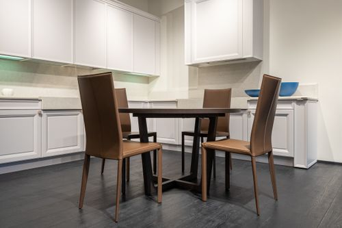 Free Modern kitchen with white empty units and square dining table with comfy chairs Stock Photo