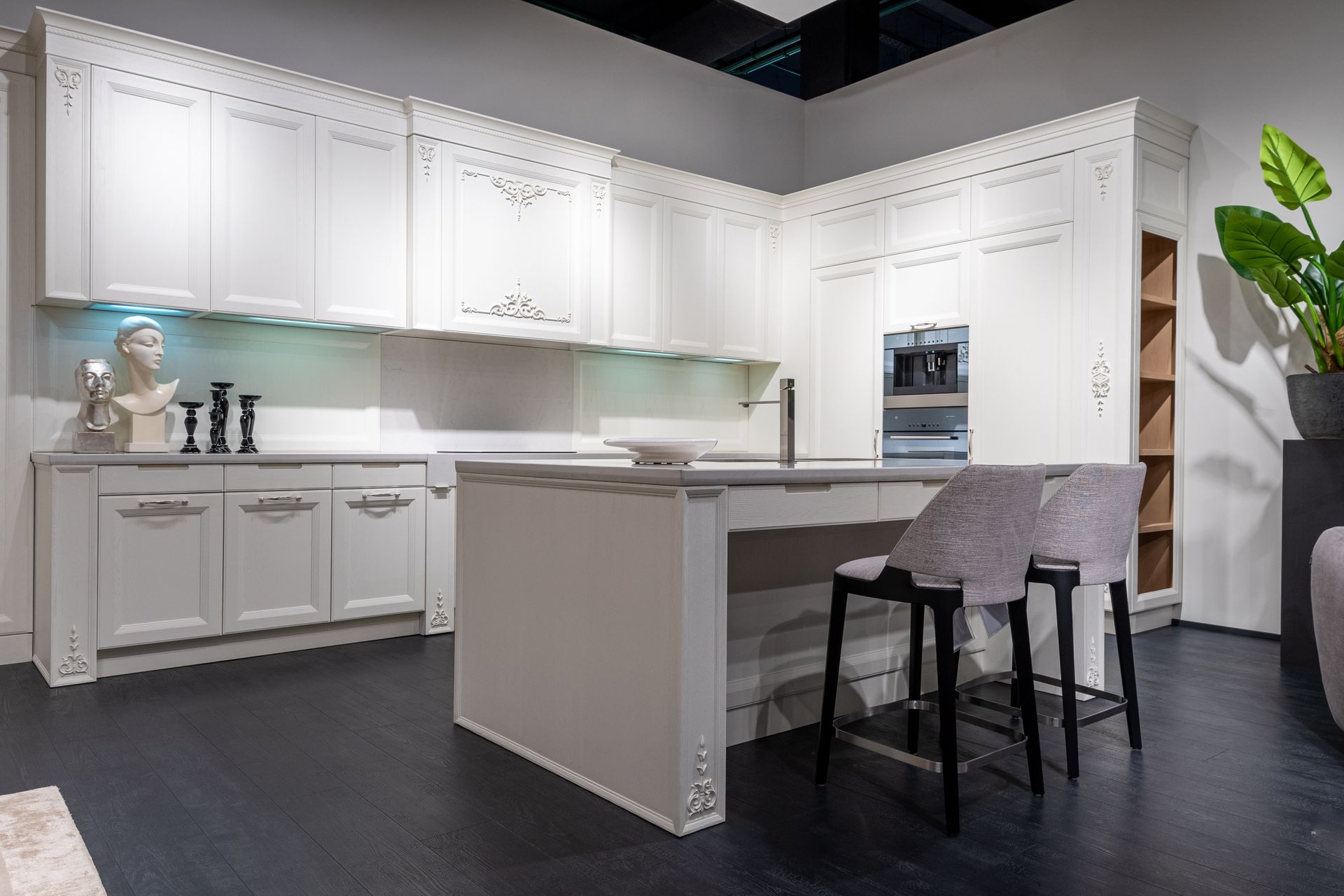 Trendy interior design of modern kitchen with white furniture and built in appliances