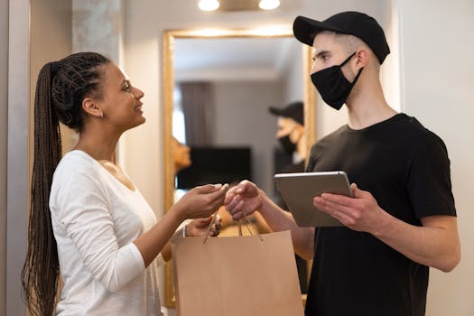 Woman receives package from masked delivery man at home, ensuring safe and efficient service.