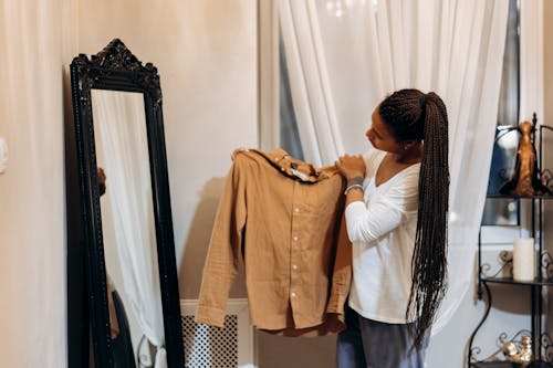 A Woman Checking a Brown Long Sleeves Shirt