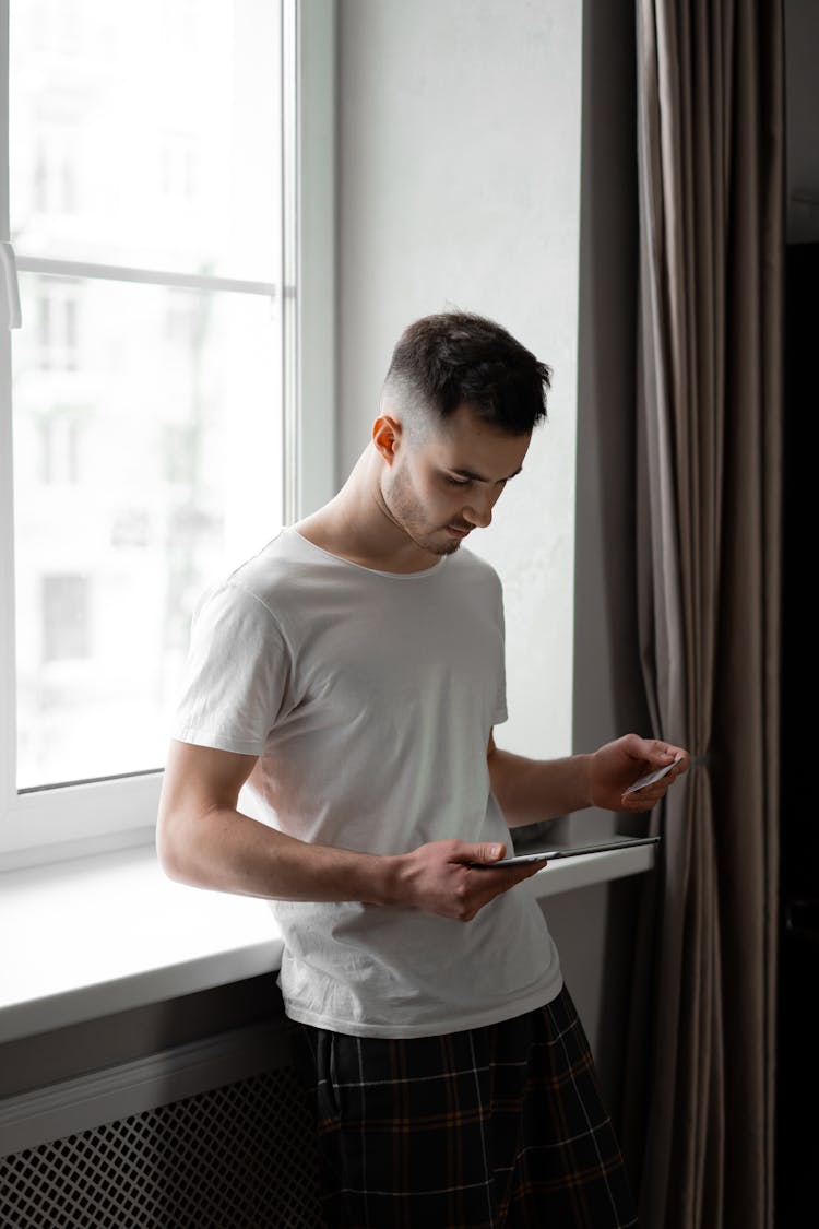 A Man Using A Tablet And Credit Card For Online Transaction