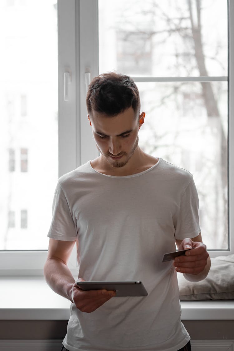 A Man Using His Tablet And Credit Card For Digital Transaction