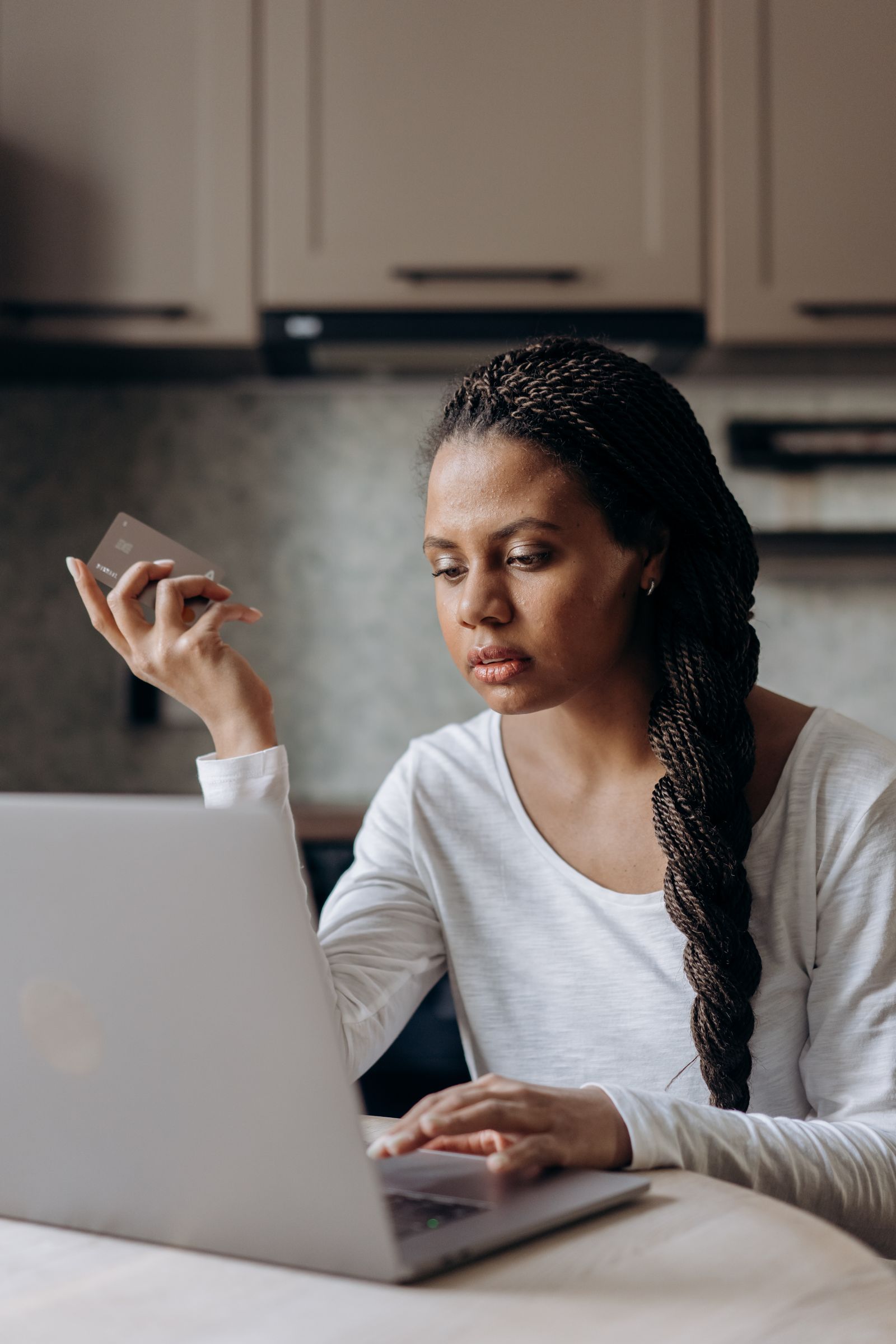Persona utilizando un portátil y una tarjeta para gestionar sus finanzas online