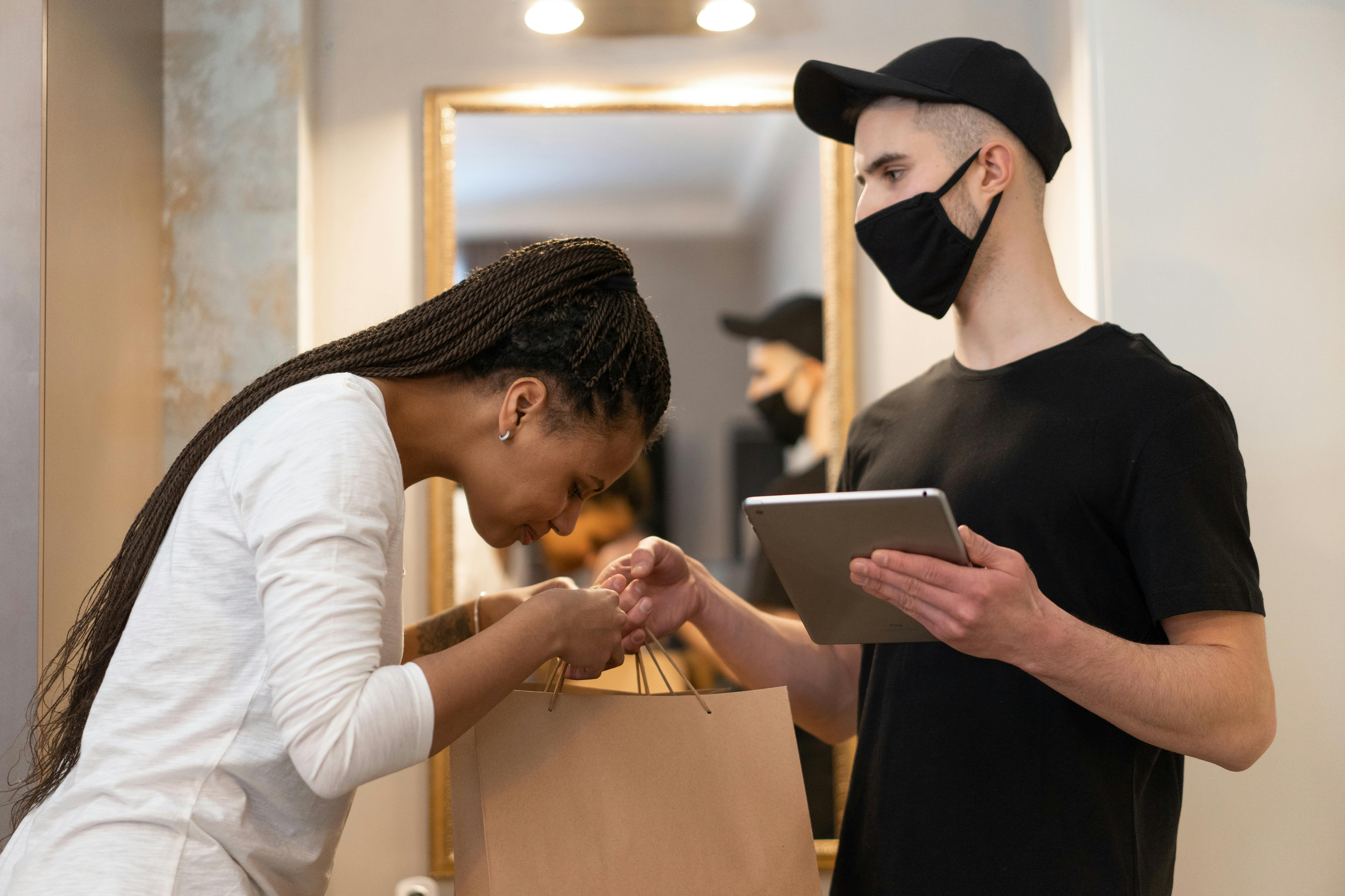 a woman receiving a delivery of paper bags