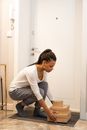 A Woman Picking Up Boxes of Delivery from the Doorway