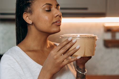 Woman in White Shirt Holding Clear Drinking Glass