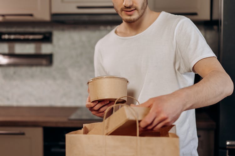 Man Grabbing Take-out Box From Paper Bag