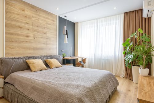 Free Bright modern bedroom with wooden accents, natural light, and cozy decor. Stock Photo