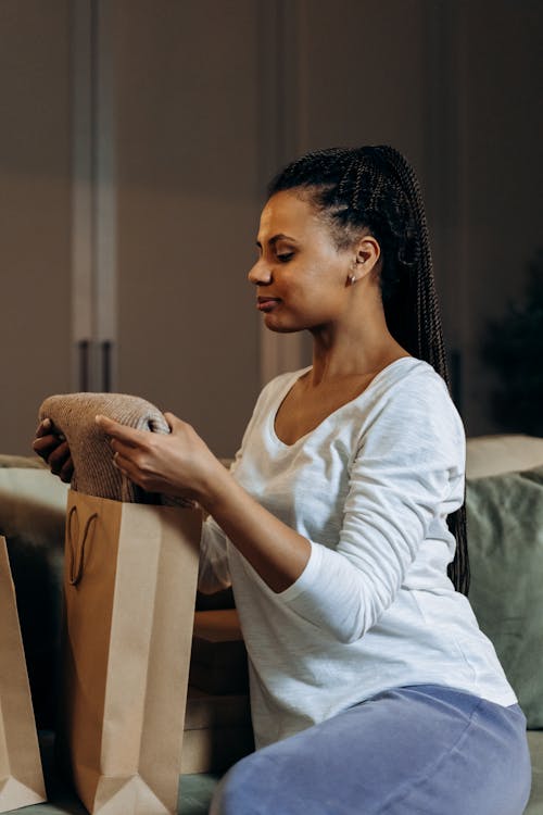 Woman Grabbing a Fabric From a Brown Paper Bag