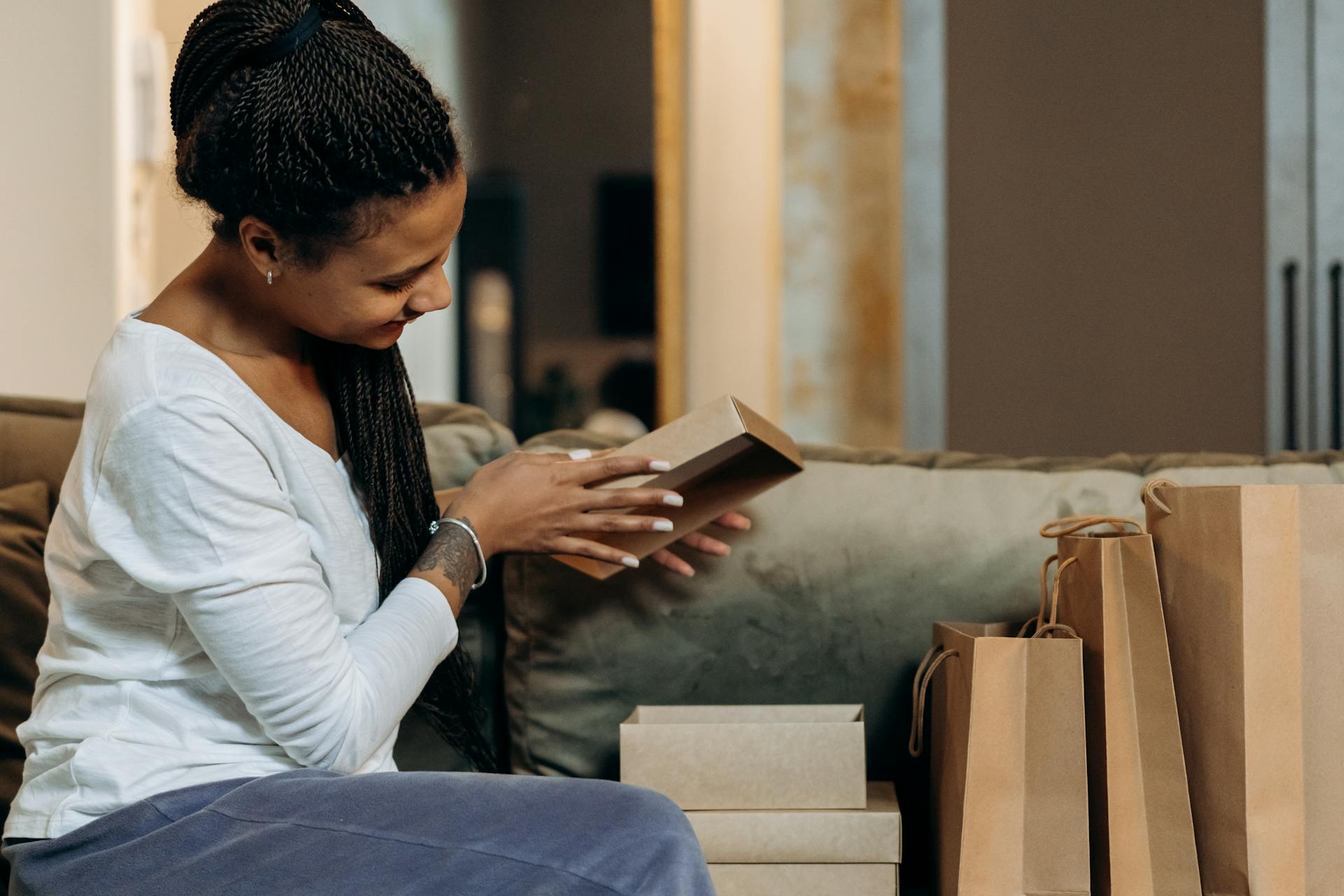 A woman enjoys her eco-friendly shopping haul with paper bags and boxes at home.