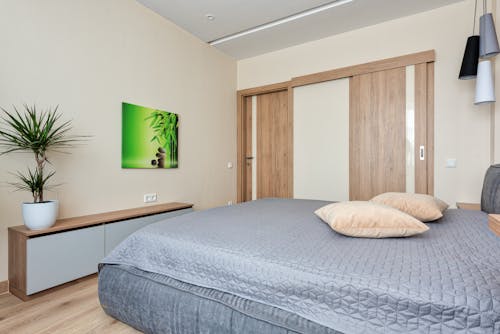 Gray Bed beside Brown Wooden Door