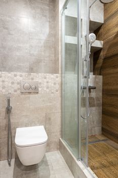 A sleek, modern bathroom featuring a shower stall and wall-mounted toilet.