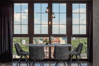 Stylish dining room with large windows overlooking a vibrant cityscape