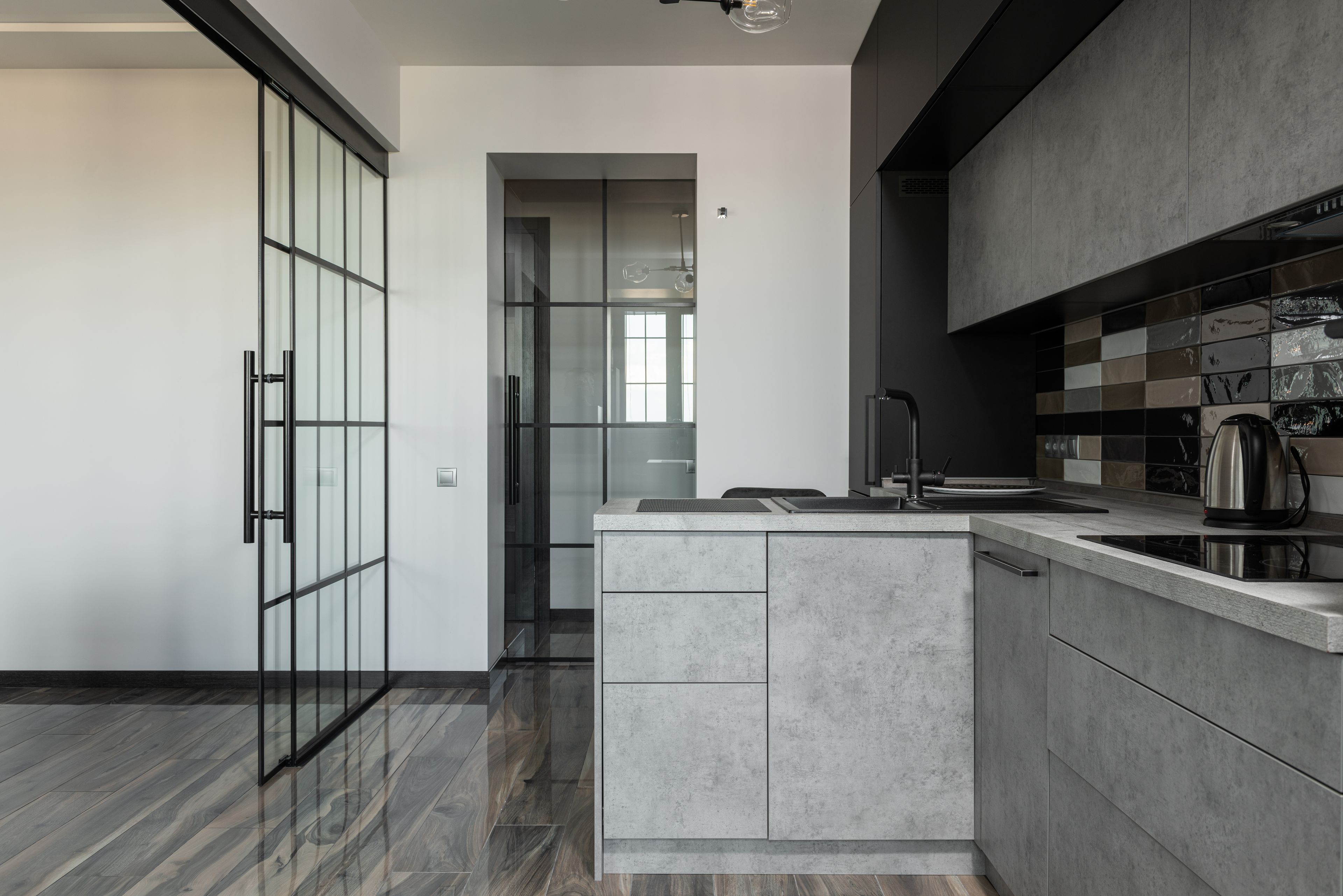 A glass partition separating a kitchen from the living space