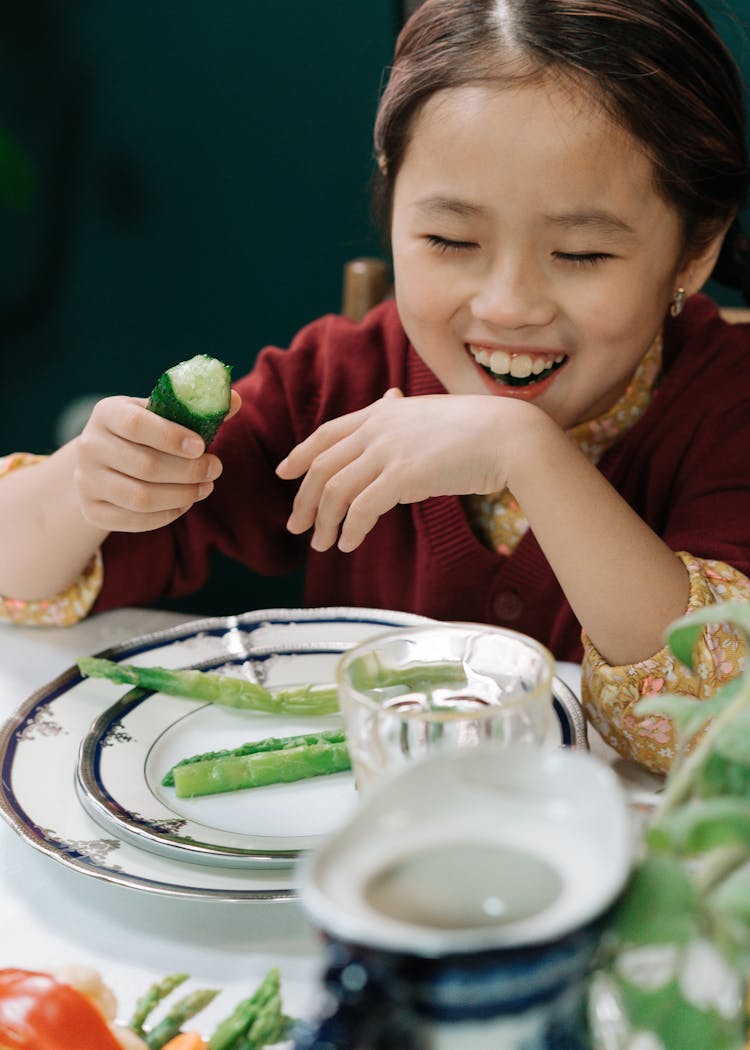 Young Girl Eating Vegetable