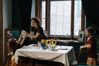 Woman in Black Shirt Sitting on Chair in Front of Table