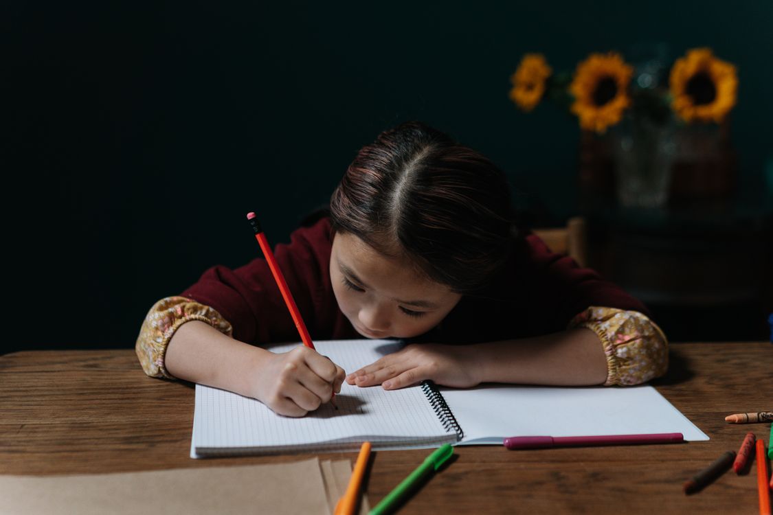 Writing Girl A Girl Writing on a Notebook Using a Pencil · Free Stock Photo
