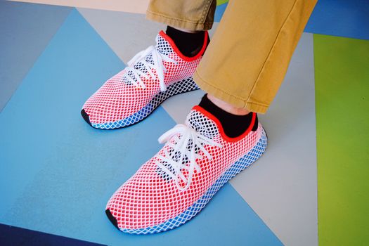 Close-up of vibrant sneakers on a geometric pattern floor.
