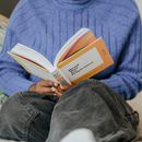 Person in Blue Sweater Reading Book