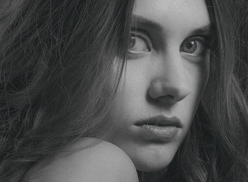Free Close-up black and white portrait of a woman looking intensely at the camera. Stock Photo