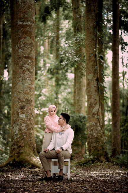 A loving couple embraces in a serene forest setting, highlighting romance and nature.
