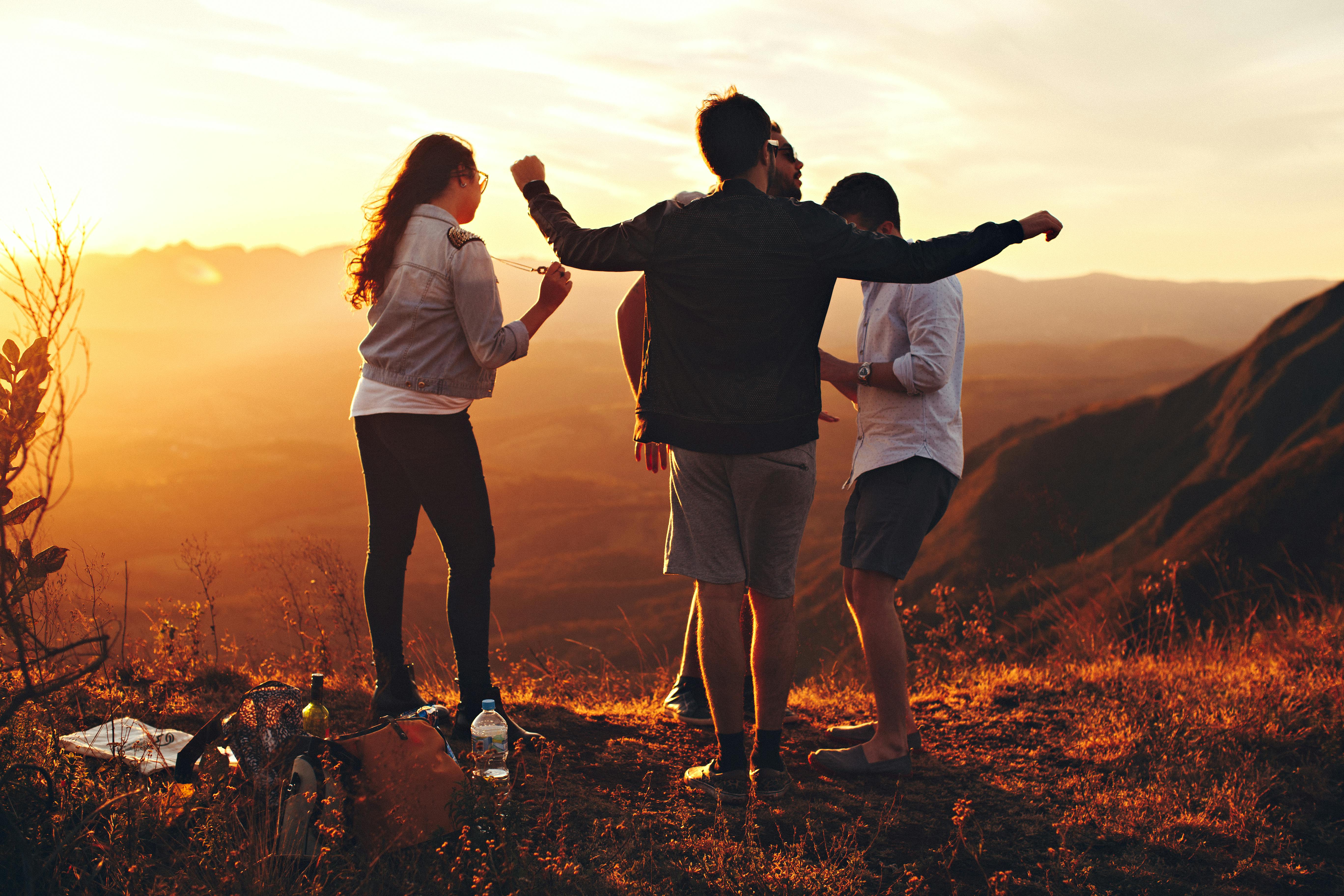 Four person standing at top of the mountain. | Photo: Pexels