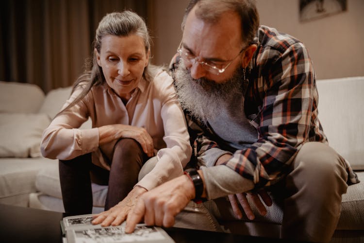 Mature Couple Looking At The Old Photos 