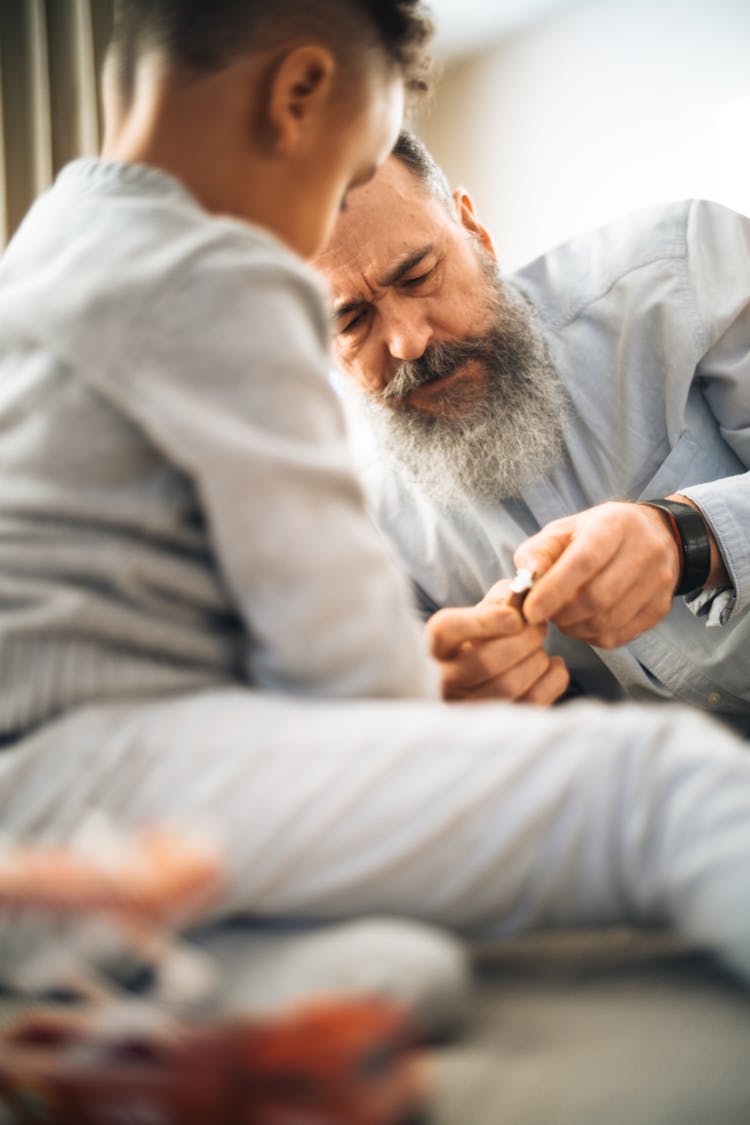 Grandfather And Grandchild Sitting Next To Each Other