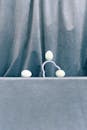 Composition with Three White Eggs and a Holder and Blue Drape