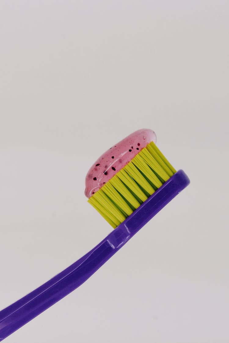 Yellow And Purple Toothbrush With Toothpaste