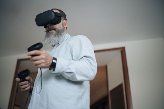 Elderly man wearing VR headset experiencing virtual reality at home.