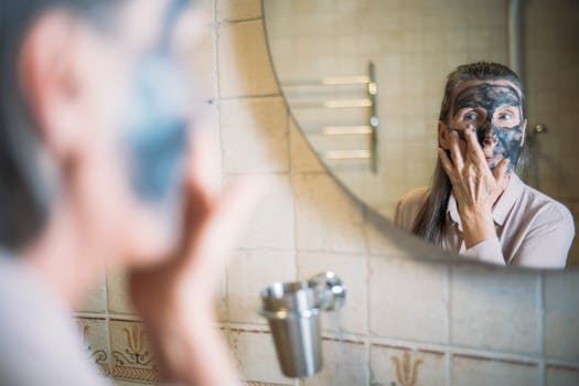An elderly woman applying a face mask while looking in the bathroom mirror promoting self-care.