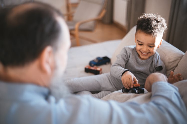 A Boy Playing With A Toy Car