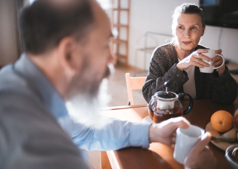 An older couple sharing coffee in a warm interior.