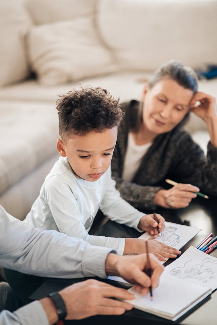 A Boy Drawing On White Paper