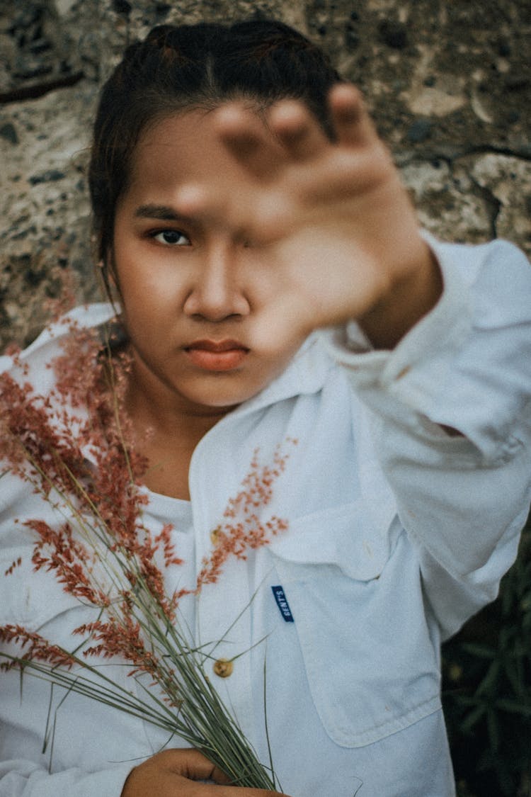 Angry Ethnic Girl With Plants Pulling Hand At Camera