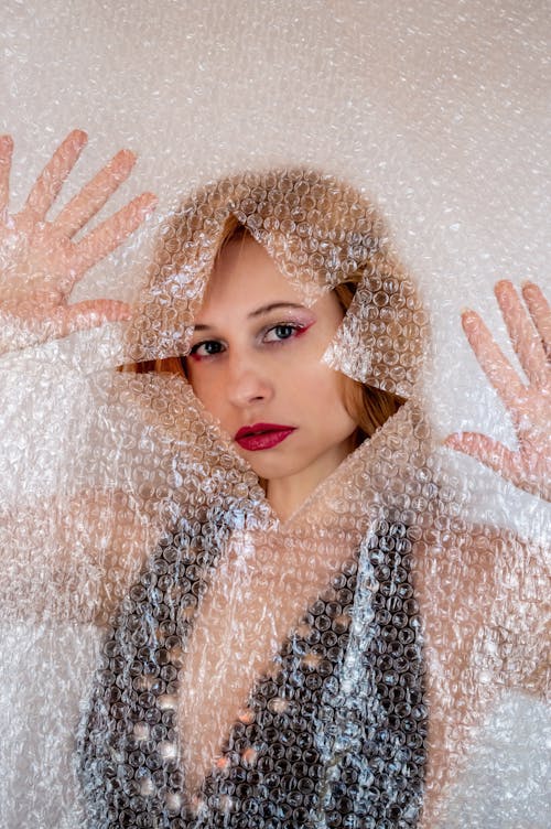 Attractive woman standing behind polyethylene curtain