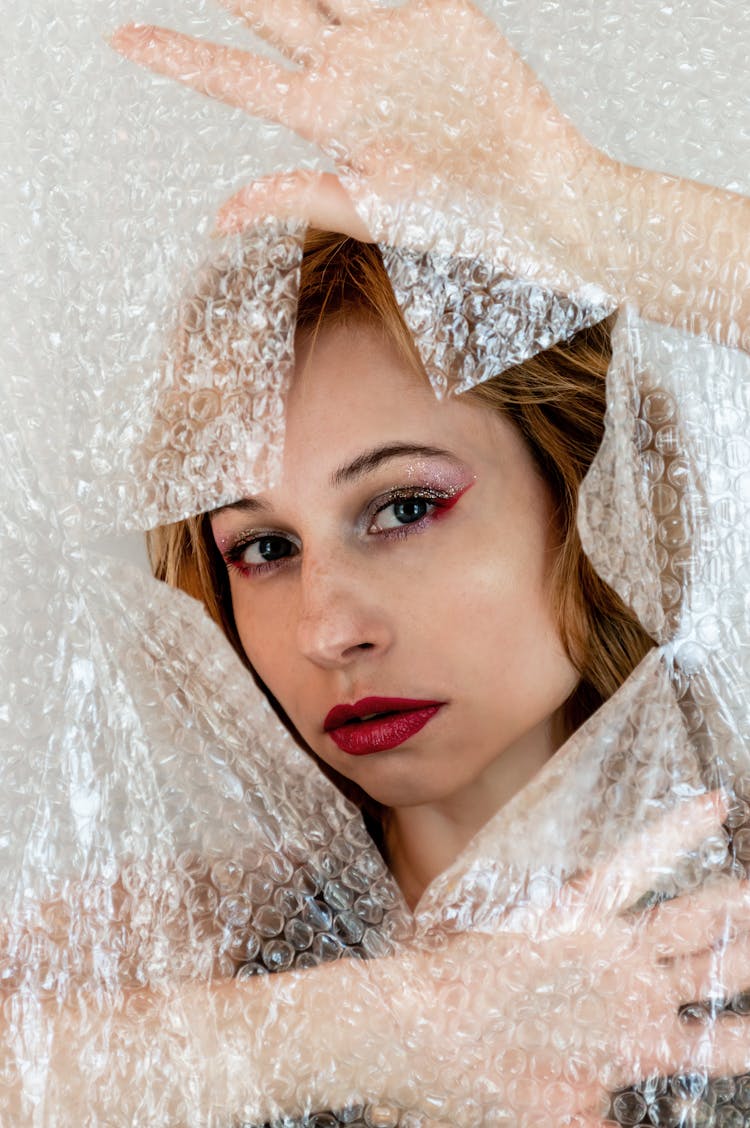 Model With Makeup Peeping Out Of Bubble Pack Hole