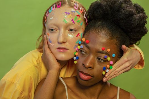 Diverse women with colorful stickers and pom pom on faces