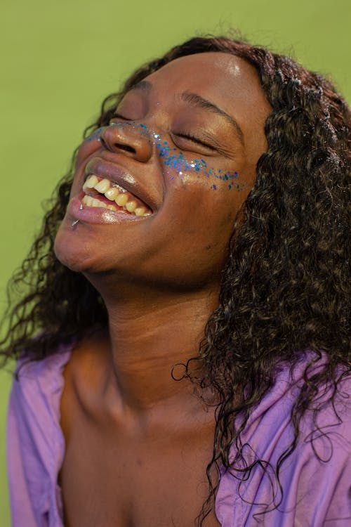 Smiling black woman with sequins on face