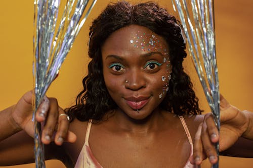 Happy black woman with shimmering rhinestones on face