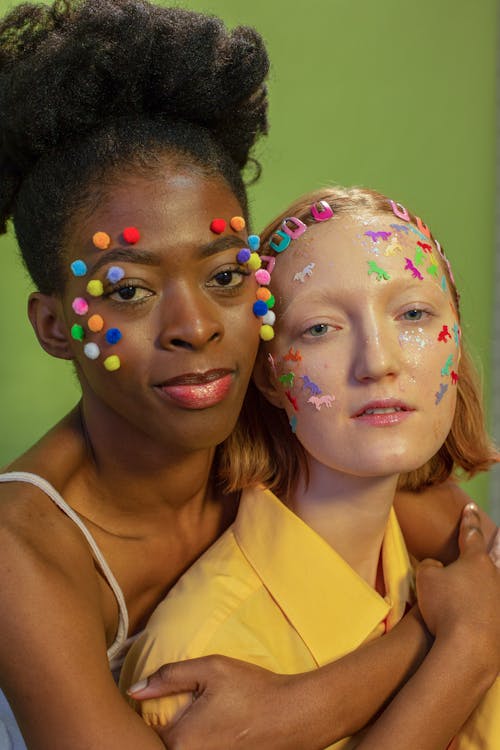 Multiethnic women with colorful stickers and cotton balls on faces