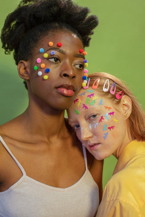 Diverse friends with colorful cotton balls and many stickers on faces on green background