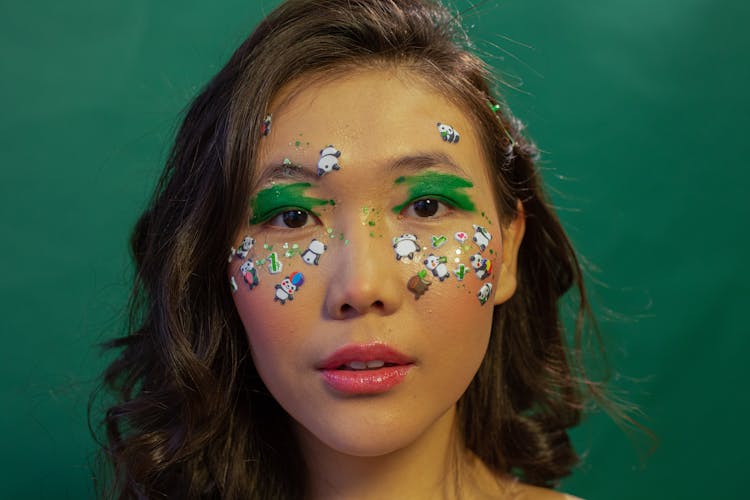 Asian Woman With Green Paint And Stickers On Face