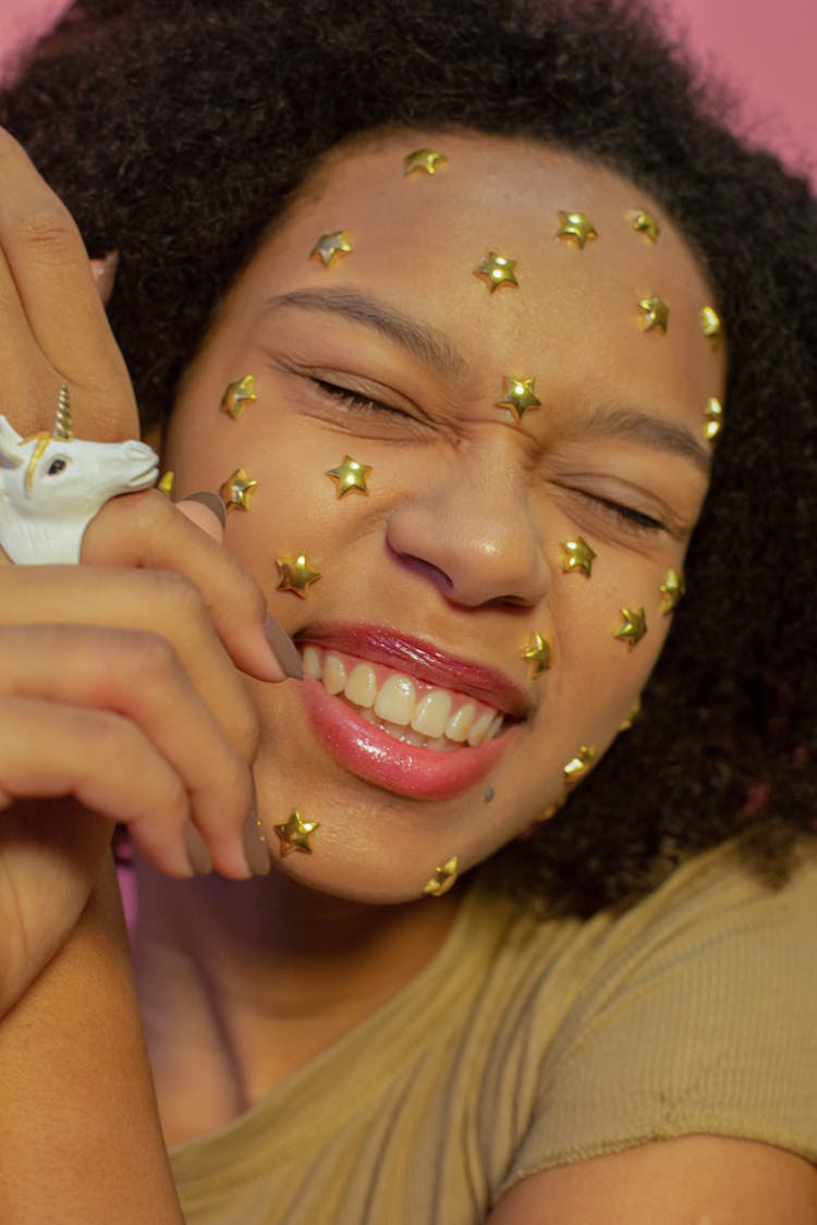 Portrait Of A Woman On Pink Background, With Unicorn And Stars On Face 