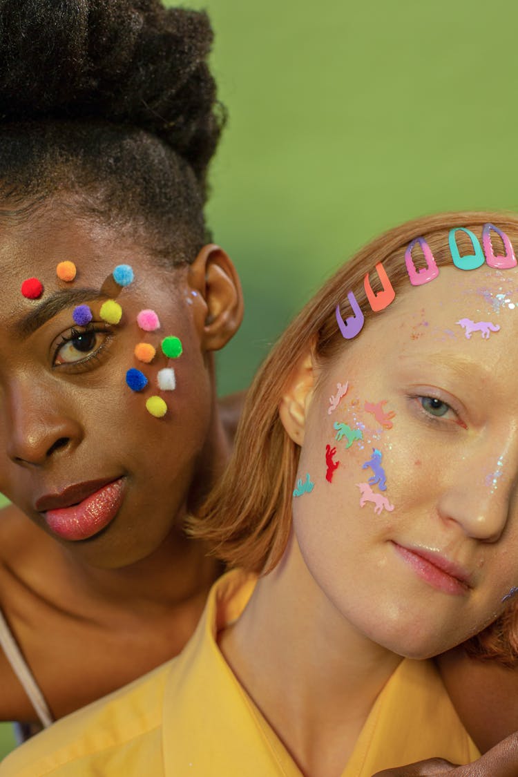 Portrait Of Girls With Stickers And Pompoms On Their Faces