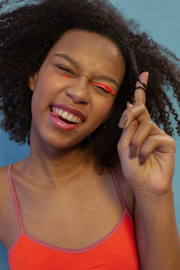 A Smiling Woman Twisting Her Hair