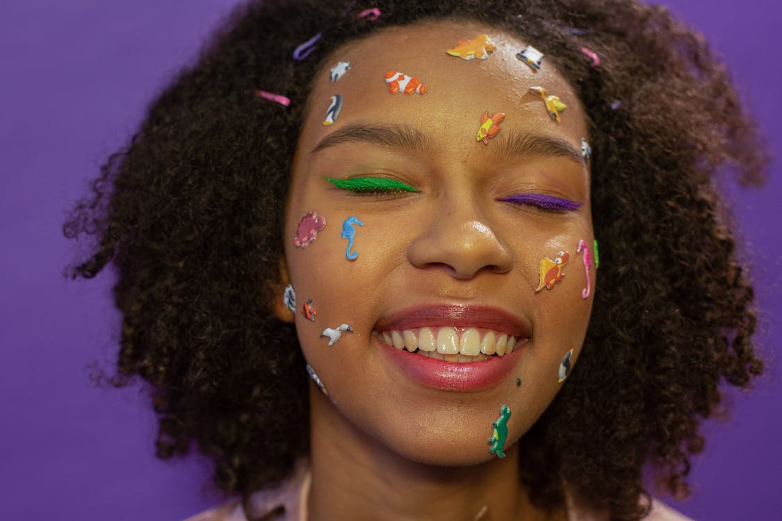 Free Smiling Woman with Colorful Stickers on Face Stock Photo