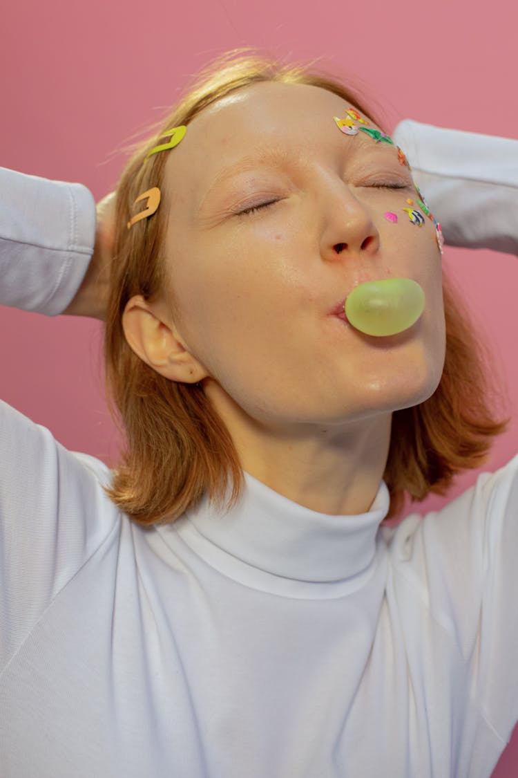 Female Blowing Bubble With Gum With Stickers On Face